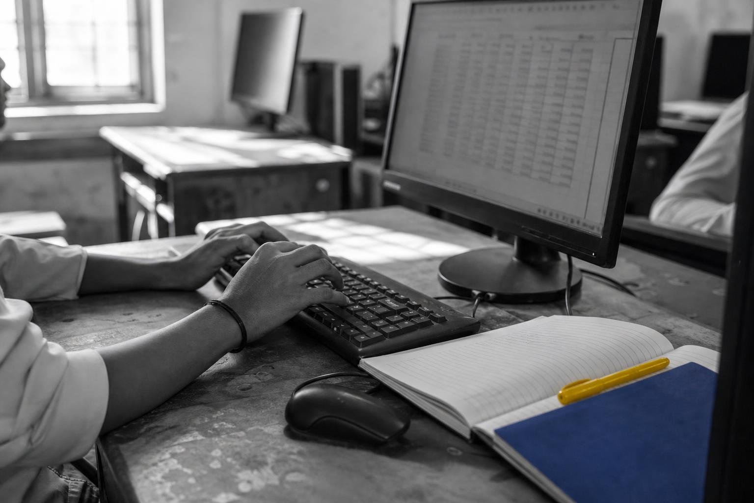Student's hands on a keyboard with accounting software open on the screen